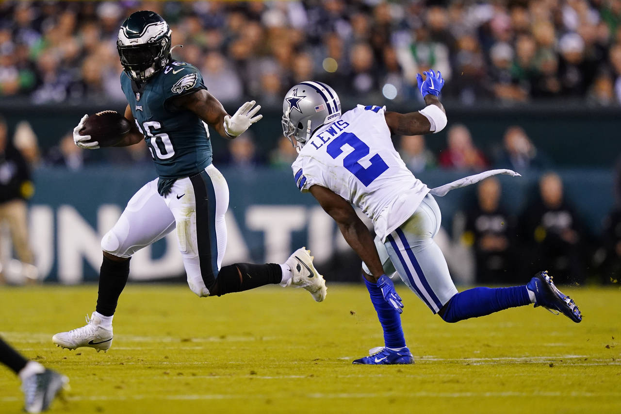 Philadelphia Eagles' Miles Sanders runs with the ball past Dallas Cowboys' Jourdan Lewis during the...