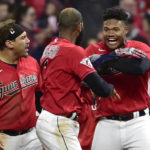 
              Cleveland Guardians' Oscar Gonzalez, right, and Josh Naylor, left, celebrate with Amed Rosario, center, after the Guardians defeated the New York Yankees 6-5 in Game 3 of a baseball AL Division Series, Saturday, Oct. 15, 2022, in Cleveland. (AP Photo/Phil Long)
            