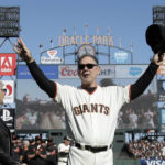 
              FILE - San Francisco Giants manager Bruce Bochy gestures toward fans next to his wife Kim during a ceremony honoring Bochy after a baseball game between the Giants and the Los Angeles Dodgers in San Francisco, Sunday, Sept. 29, 2019. The Texas Rangers have hired Bruce Bochy as their new manager, bringing the three-time World Series champion out of retirement to take over a team that has had six consecutive losing seasons. Texas made the surprise announcement Friday, Oct. 21, 2022, just more than two weeks after its season ended. (AP Photo/Jeff Chiu, Pool, Filer)
            