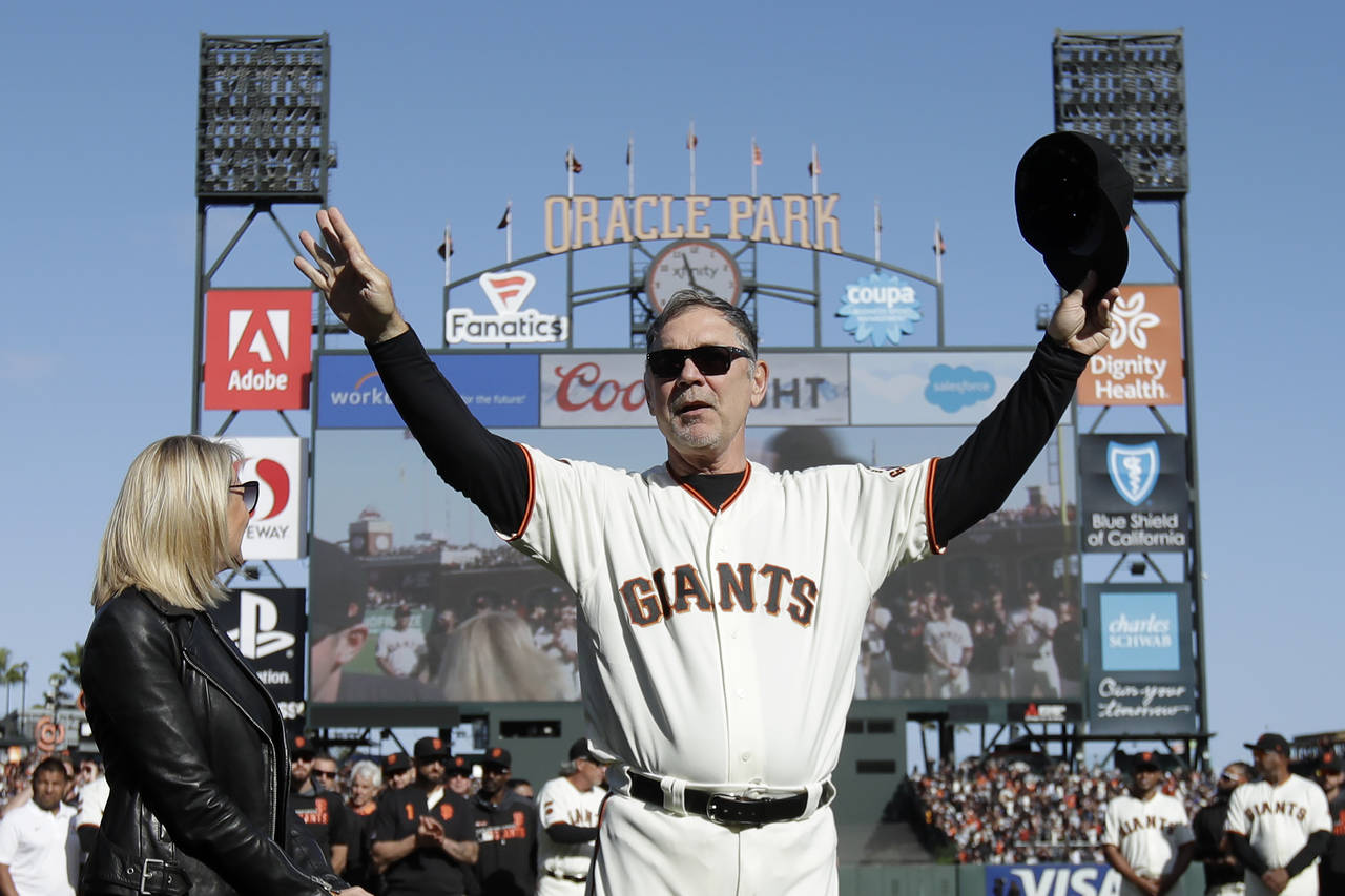 FILE - San Francisco Giants manager Bruce Bochy gestures toward fans next to his wife Kim during a ...