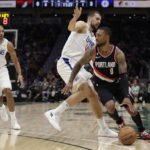 
              Portland Trailblazers' Damian Lillard drives around Los Angeles Clippers' Ivica Zubac with Nicolas Batum (33) behind during the first half of an NBA preseason basketball game, Monday, Oct. 3, 2022, in Seattle. (AP Photo/ John Froschauer)
            