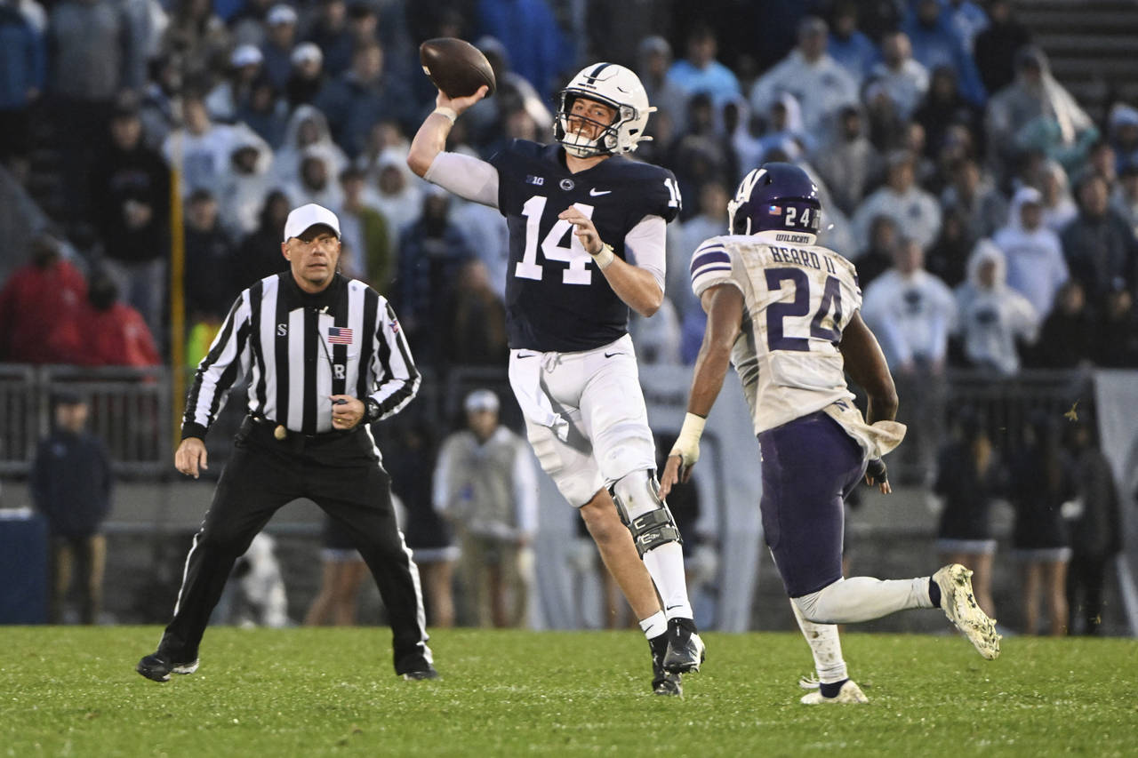 Penn State quarterback Sean Clifford (14) throws a pass while being pressured by Northwestern defen...