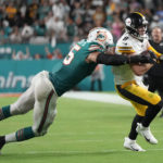 
              Miami Dolphins linebacker Jaelan Phillips (15) grabs Pittsburgh Steelers quarterback Kenny Pickett (8) during the second half of an NFL football game, Sunday, Oct. 23, 2022, in Miami Gardens, Fla. (AP Photo/Rebecca Blackwell)
            