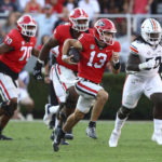 
              Georgia quarterback Stetson Bennett breaks away for a 60-plus yard touchdown run on a quarterback keeper against Auburn during the second half of an during an NCAA college football game, Saturday, Oct. 8, 2022, in Athens, Ga. (Curtis Compton/Atlanta Journal-Constitution via AP)
            