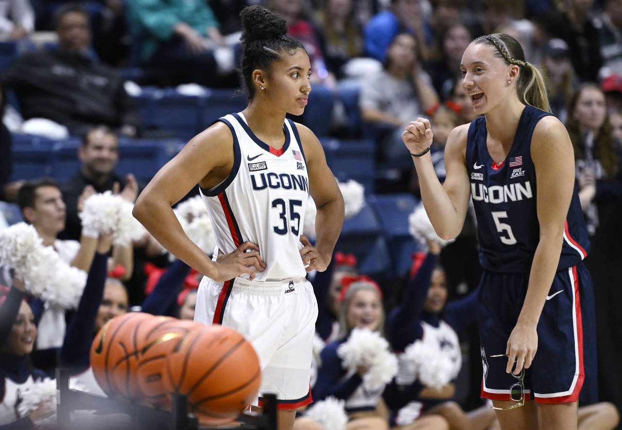 Connecticut's Paige Bueckers, right, talks with teammate Azzi Fudd, left, as Fudd participates in a...