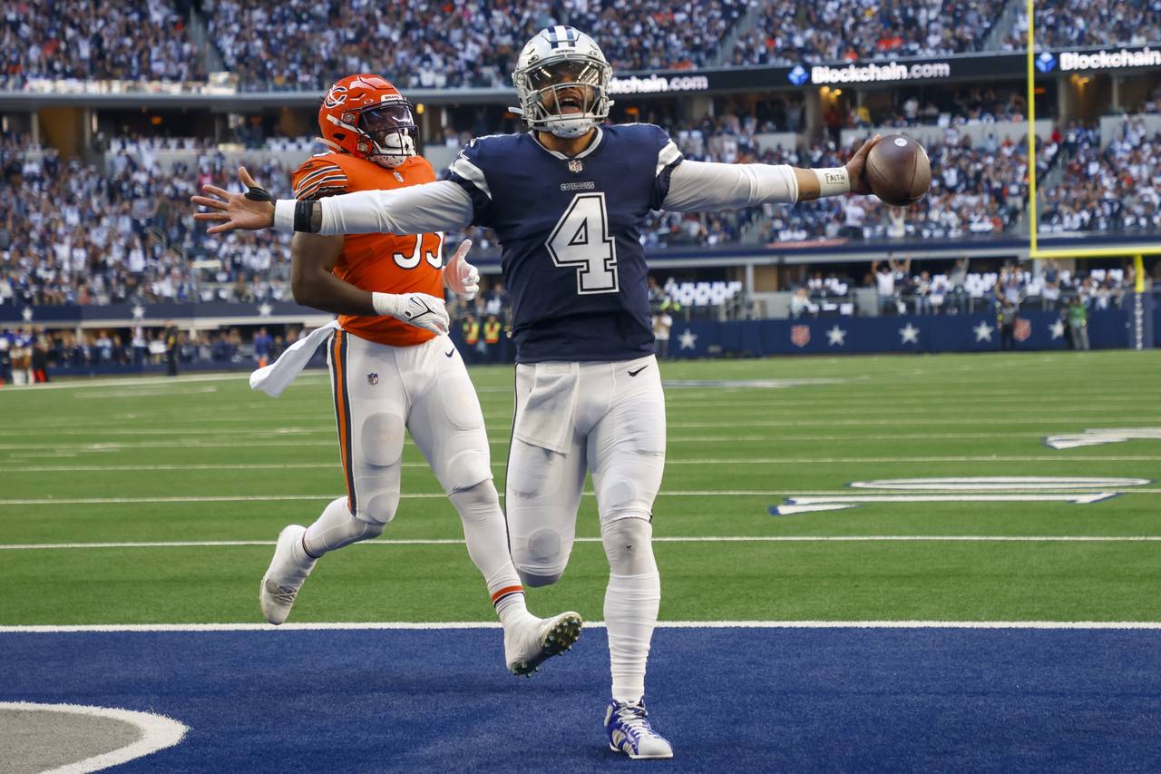 Dallas Cowboys' Dak Prescott runs for a touchdown during the first half of an NFL football game aga...