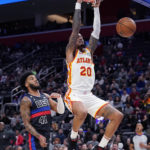 
              Atlanta Hawks forward John Collins (20) dunks as Detroit Pistons forward Saddiq Bey (41) defends during the first half of an NBA basketball game, Wednesday, Oct. 26, 2022, in Detroit. (AP Photo/Carlos Osorio)
            