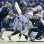 
              Navy fullback Daba Fofana, center, is tackled by Houston linebackers Donavan Mutin (3), Treylin Payne (29) and Jamal Morris (25) during the first half of an NCAA college football game, Saturday, Oct. 22, 2022, in Annapolis, Md. Navy's Kip Frankland, left, tries to help block on the play. (AP Photo/Julio Cortez)
            