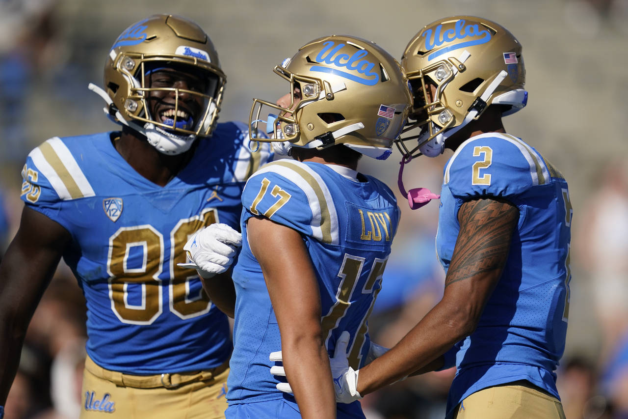 UCLA receiver Logan Loya (17) celebrates with tight end Michael Ezeike (86) and wide receiver Titus...