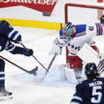 
              Winnipeg Jets' Adam Lowry (17) tries to get at the rebound off of New York Rangers goaltender Jaroslav Halak (41) as Rangers' Jacob Trouba (8) defends during the second period of an NHL hockey game Friday, Oct. 14, 2022, in Winnipeg, Manitoba. (John Woods/The Canadian Press via AP)
            