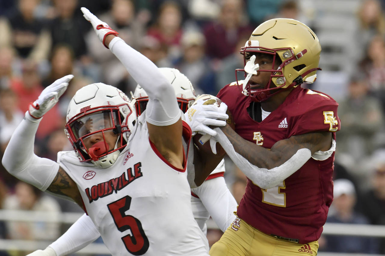 Boston College wide receiver Zay Flowers hauls in a pass despite the attempted breakup by Louisvill...