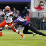 
              Cleveland Browns running back Kareem Hunt (27) tries to escape from Baltimore Ravens safety Kyle Hamilton (14) after a catch in the first second of an NFL football game, Sunday, Oct. 23, 2022, in Baltimore. (AP Photo/Julio Cortez)
            
