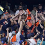 
              Fans reach for Houston Astros Yordan Alvarez's two-run home run against the Seattle Mariners during the sixth inning in Game 2 of an American League Division Series baseball game in Houston, Thursday, Oct. 13, 2022. (AP Photo/Kevin M. Cox)
            