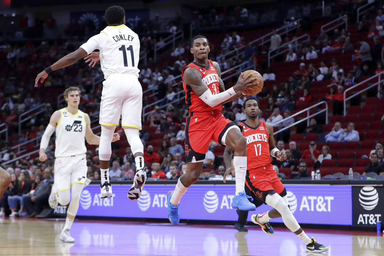 Houston Rockets guard Kevin Porter Jr. jumps to pass the ball as Utah Jazz guard Mike Conley (11) d...