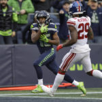 
              Seattle Seahawks wide receiver Tyler Lockett, left, scores a touchdown past New York Giants safety Xavier McKinney (29) during the second half of an NFL football game in Seattle, Sunday, Oct. 30, 2022. (AP Photo/John Froschauer)
            