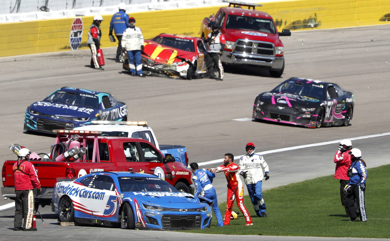 Bubba Wallace, center right, shoves Kyle Larson (5) after they crashed during a NASCAR Cup Series a...