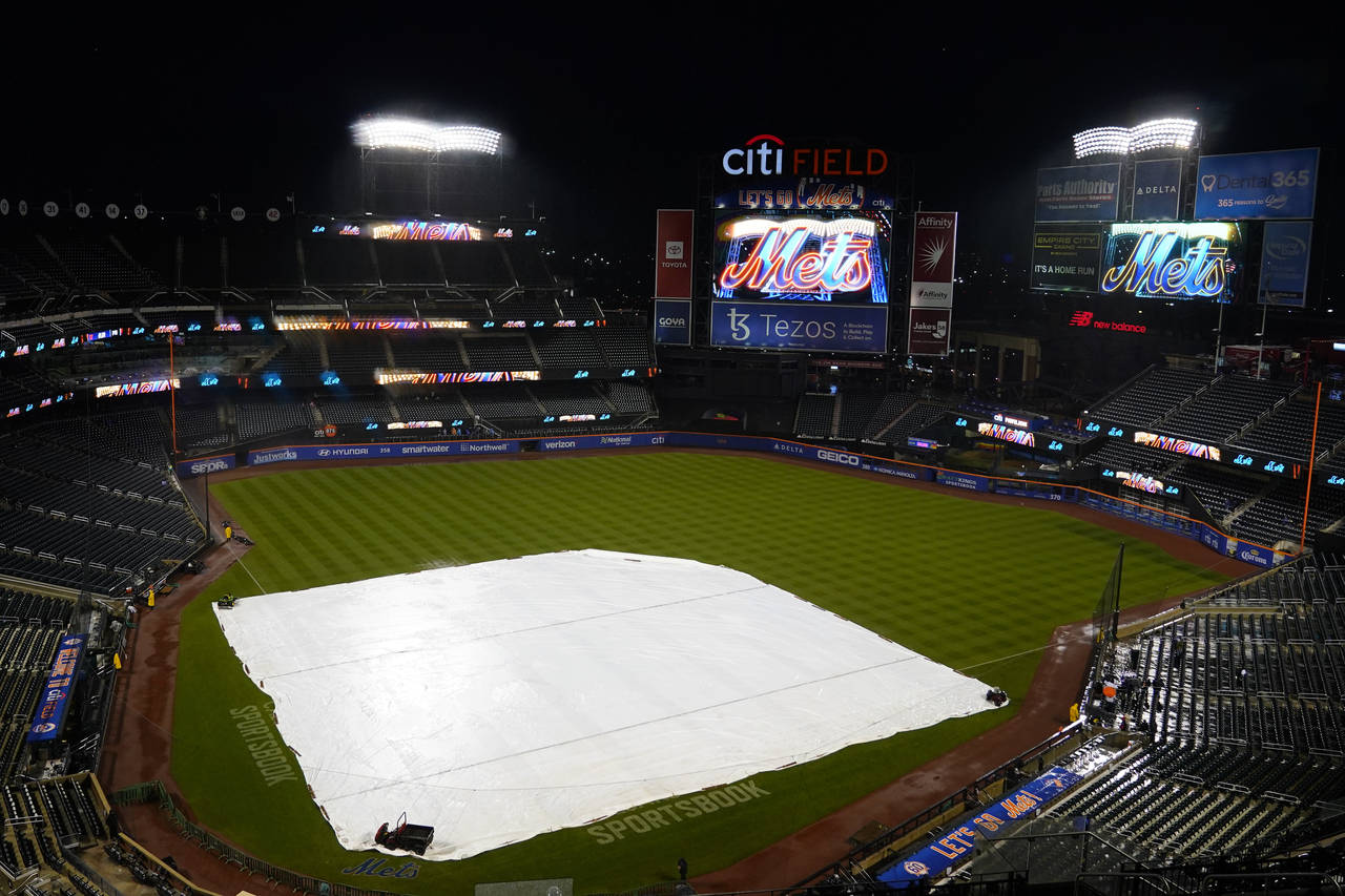 The tarp covers the field at CitiField, Monday, Oct. 3, 2022, in New York. Monday's baseball game b...