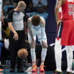 
              Charlotte Hornets guard LaMelo Ball is shaken up on a play in the second half of an NBA preseason basketball game against the Washington Wizards in Charlotte, N.C., Monday, Oct. 10, 2022. (AP Photo/Jacob Kupferman)
            