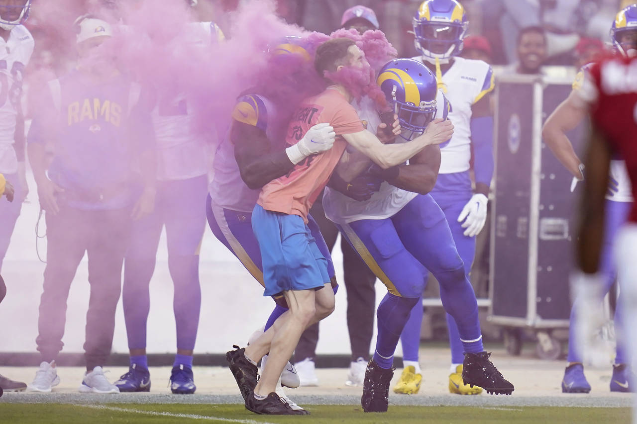 A protester is hit by Los Angeles Rams defensive end Takkarist McKinley, middle left, and linebacke...