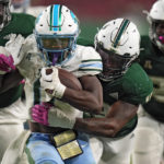 
              Tulane running back Shaadie Clayton (0) gets stopped by South Florida defensive end Tramel Logan (13) during the second half of an NCAA college football game Saturday, Oct. 15, 2022, in Tampa, Fla. (AP Photo/Chris O'Meara)
            