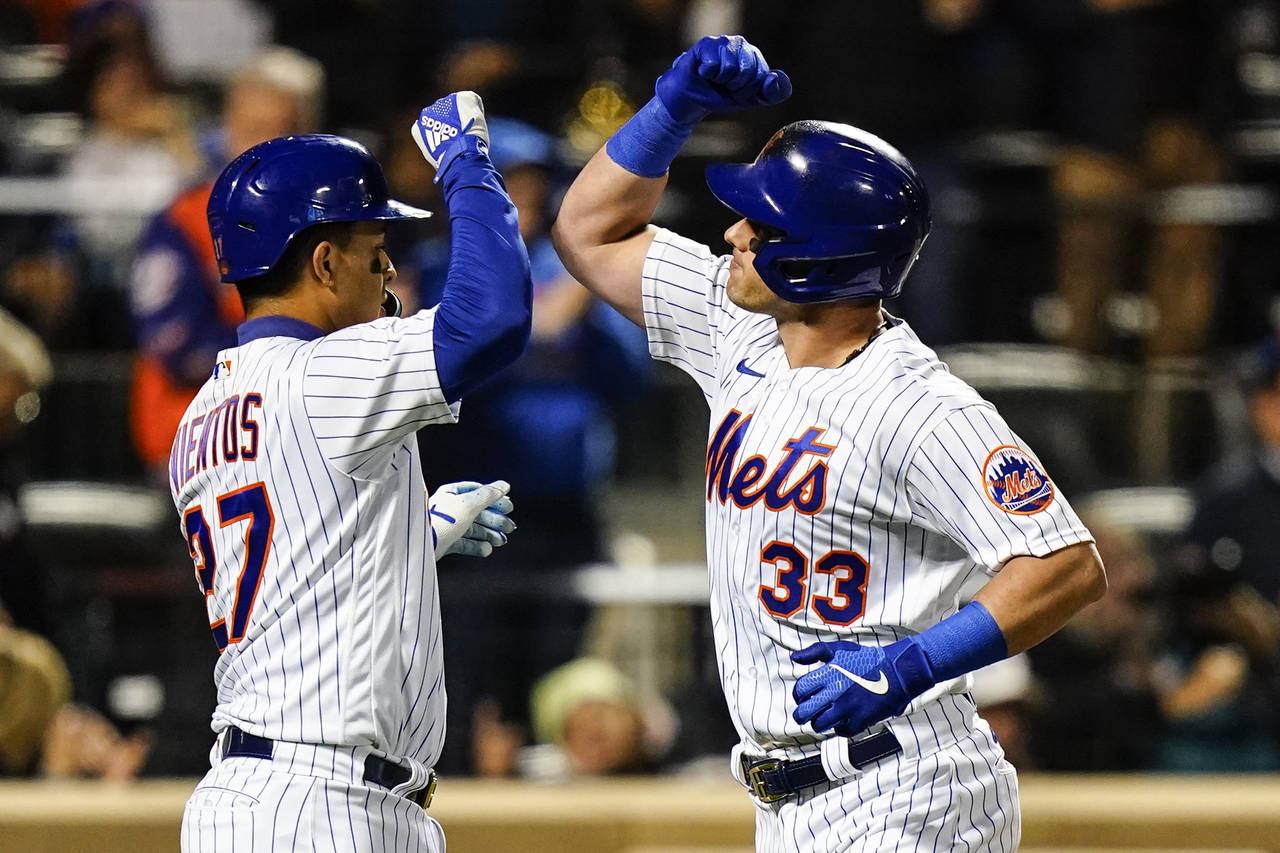 New York Mets' Mark Vientos celebrates with James McCann (33) after they scored on a three-run home...