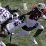 
              Kansas running back Sevion Morrison (28) gets past TCU linebacker Jamoi Hodge (6) during the first half of an NCAA college football game Saturday, Oct. 8, 2022, in Lawrence, Kan. (AP Photo/Charlie Riedel)
            