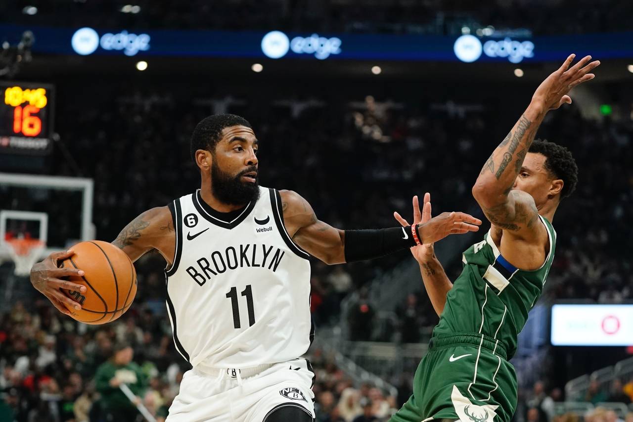 Brooklyn Nets' Kyrie Irving tries to get past Milwaukee Bucks' George Hill during the first half of...