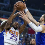 
              Phoenix Suns forward Mikal Bridges, center, pulls down a rebound against Los Angeles Clippers center Ivica Zubac, right, and forward Marcus Morris Sr. during the first half of an NBA basketball game, Sunday, Oct. 23, 2022, in Los Angeles. (AP Photo/Alex Gallardo)
            