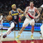 
              Denver Nuggets forward Bruce Brown (11), left, dribbles past Portland Trail Blazers forward Drew Eubanks (24) during the first half of an NBA basketball game in Portland, Ore., Monday, Oct. 24, 2022. (AP Photo/Craig Mitchelldyer)
            