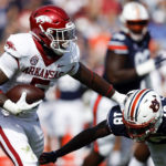 
              Arkansas running back Raheim Sanders (5) stiff arms Auburn cornerback Nehemiah Pritchett (18) as he carries the ball during the first half of an NCAA college football game Saturday, Oct. 29, 2022, in Auburn, Ala. (AP Photo/Butch Dill)
            