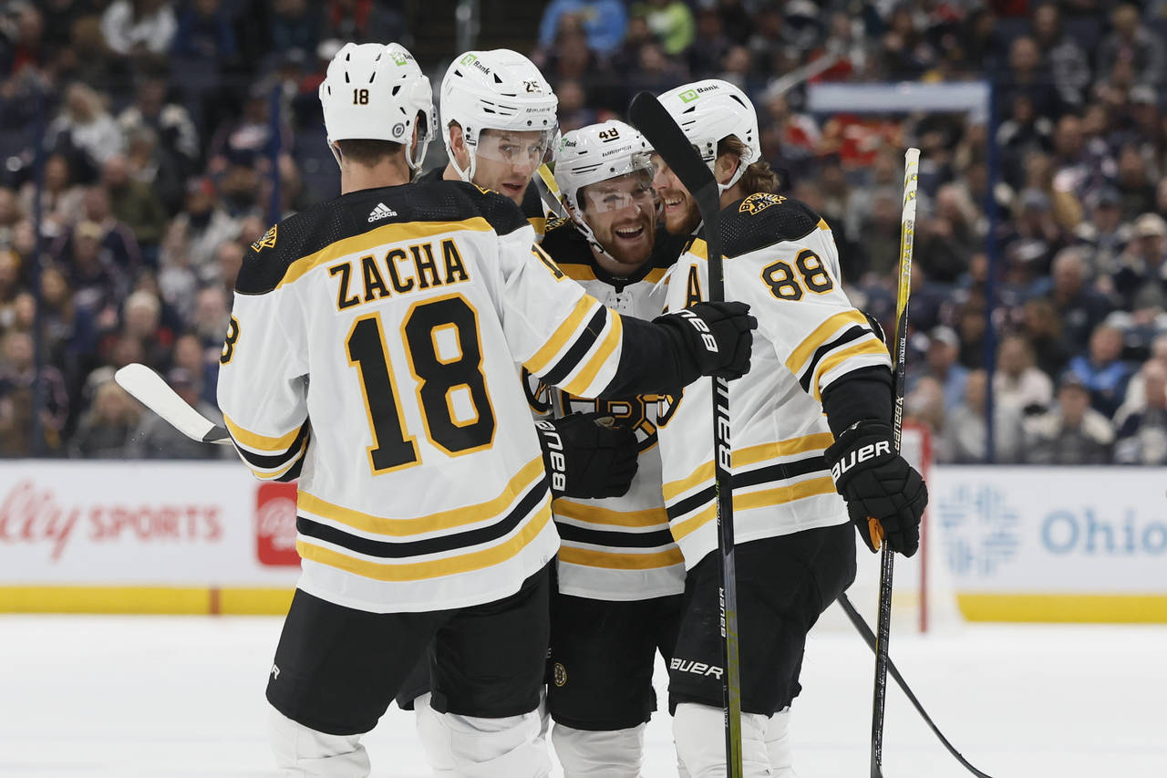 Boston Bruins' Matt Grzelcyk, second from right, celebrates with teammates after his goal against t...