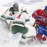 
              Montreal Canadiens' Mike Hoffman (68) is brought down by Minnesota Wild's Jon Merrill as he takes a shot on Wild goaltender Marc-Andre Fleury during the third period of an NHL hockey game, Tuesday, Oct. 25, 2022 in Montreal. (Graham Hughes/The Canadian Press via AP)
            