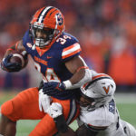 
              Syracuse running back Sean Tucker (34) is tackled by Virginia linebacker Chico Bennett Jr. (15) during the first half of an NCAA college football game Friday, Sept. 23, 2022, in Syracuse, N.Y. (AP Photo/Adrian Kraus)
            