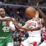 
              Boston Celtics' Al Horford passes as Chicago Bulls' Nikola Vucevic and Ayo Dosunmu (12) defend during the first half of an NBA basketball game Monday, Oct. 24, 2022, in Chicago. (AP Photo/Charles Rex Arbogast)
            