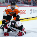
              Philadelphia Flyers' Noah Cates (49) and New Jersey Devils' Michael McLeod (20) collide during the first period of an NHL hockey game, Thursday, Oct. 13, 2022, in Philadelphia. (AP Photo/Matt Slocum)
            