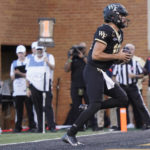 
              Wake Forest quarterback Sam Hartman (10) runs into the end zone for a touchdown against Boston College during the second half of an NCAA college football game in Winston-Salem, N.C., Saturday, Oct. 22, 2022. (AP Photo/Chuck Burton)
            