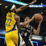 
              San Antonio Spurs guard Devin Vassell (24) shoots around Indiana Pacers forward Isaiah Jackson (22) during the first half of an NBA basketball game in Indianapolis, Friday, Oct. 21, 2022. (AP Photo/AJ Mast)
            