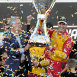 
              Joey Logano, right, and NASCAR President Steve Phelps hold up the championship trophy after winning a NASCAR Cup Series auto race and championship Sunday, Nov. 6, 2022, in Avondale, Ariz. (AP Photo/Rick Scuteri)
            