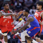 
              Los Angeles Clippers guard John Wall, middle, passes the ball away from Houston Rockets forward Tari Eason (17) and guard Daishen Nix, right, during the first half of an NBA basketball game Wednesday, Nov. 2, 2022, in Houston. (AP Photo/Michael Wyke)
            