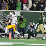 
              Wyoming quarterback Jayden Clemons (12) scores a touchdown against Colorado State on a keeper during the second quarter of an NCAA college football game Saturday, Nov. 12, 2022, in Fort Collins, Colo. (Andy Cross/The Denver Post via AP)
            