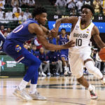 
              FILE - Baylor guard Adam Flagler (10) dribbles past Kansas guard Ochai Agbaji (30) during an NCAA college basketball game Feb. 26, 2022, in Waco, Texas. While Baylor returns only two starters – Flagler and big man Flo Thamba – the roster includes two guards coming back from injury, two Division I transfers and the league’s top incoming freshman. (AP Photo/Ray Carlin, File)
            