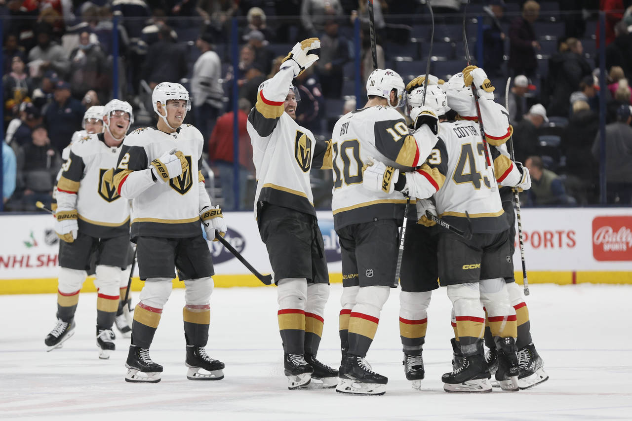 Vegas Golden Knights players celebrate after their win over the Columbus Blue Jackets in an NHL hoc...