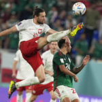 
              Poland's Grzegorz Krychowiak jumps for the ball against Mexico's Luis Chavez, right, during the World Cup group C soccer match between Mexico and Poland, at the Stadium 974 in Doha, Qatar, Tuesday, Nov. 22, 2022. (AP Photo/Martin Meissner)
            