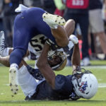 
              Navy fullback Daba Fofana, top, is tackled by Central Florida defensive back Koby Perry during the first half of an NCAA college football game, Saturday, Nov. 19, 2022, in Orlando, Fla. (AP Photo/John Raoux)
            