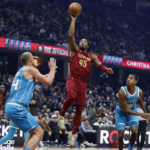 
              Cleveland Cavaliers guard Donovan Mitchell (45) shoots against Charlotte Hornets center Mason Plumlee (24) and guard Theo Maledon (9) during the first half of an NBA basketball game Friday, Nov. 18, 2022, in Cleveland. (AP Photo/Ron Schwane)
            