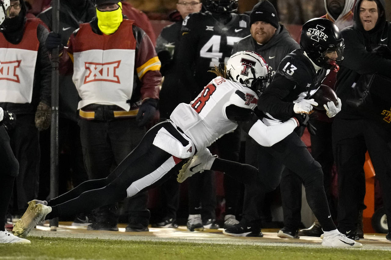 Iowa State wide receiver Jaylin Noel (13) tries to break a tackle by Texas Tech defensive back Tyle...