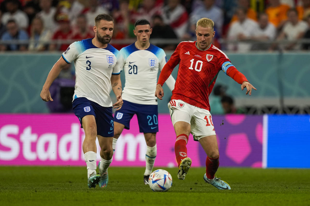 Wales' Aaron Ramsey, right, vies for the ball with England's Luke Shaw, left, and Phil Foden during...