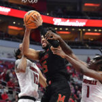 
              Maryland forward Patrick Emilien (15) attempts a shot through the defense of Louisville forward JJ Traynor (12), and guard Mike James (1) during the second half of an NCAA college basketball game in Louisville, Ky., Tuesday, Nov. 29, 2022. Maryland won 79-54. (AP Photo/Timothy D. Easley)
            