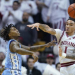
              CORRECTS CITY TO BLOOMINGTON, INSTEAD OF INDIANAPOLIS - North Carolina guard Caleb Love, left, passes the ball past Indiana guard Jalen Hood-Schifino (1) during the second half of an NCAA college basketball game in Bloomington, Ind., Wednesday, Nov. 30, 2022. (AP Photo/Darron Cummings)
            
