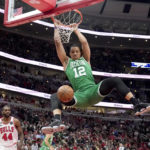 
              Boston Celtics' Grant Williams dunks the ball as Chicago Bulls' Patrick Williams watches during the first half of an NBA basketball game Monday, Nov. 21, 2022, in Chicago. (AP Photo/Charles Rex Arbogast)
            